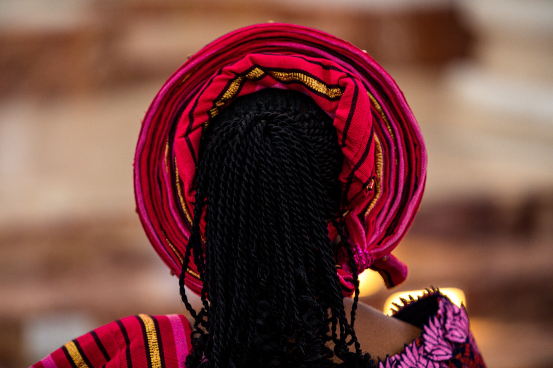 Back view of a braided hairstyle with a red patterned headwrap